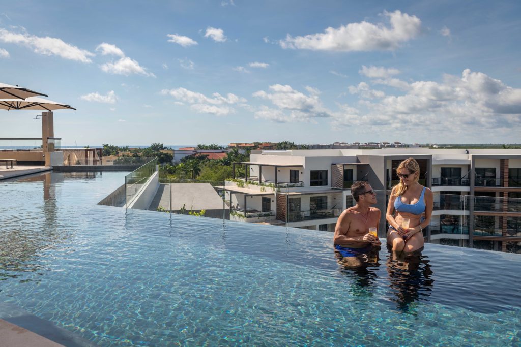 Hotel rooftop pool and two vacationers at Ventus Ha' resort in Riviera Maya, Puerto Morelos, Mexico